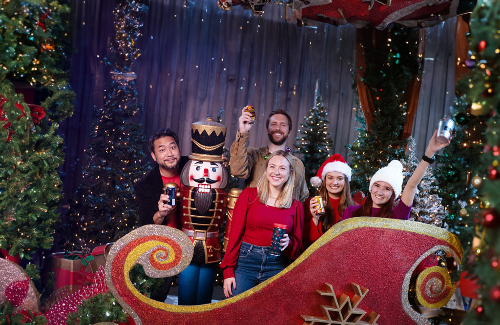 Group of friends at the Zoo taking picture inside a sleigh for Dallas Zoo After Dark holiday event for adults only Wild Lights