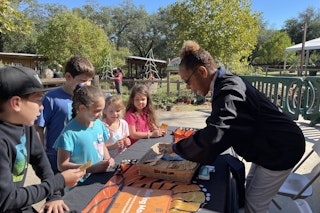 Children gathered around an activity table during Homeschool Day; an Education Program at the Dallas Zoo