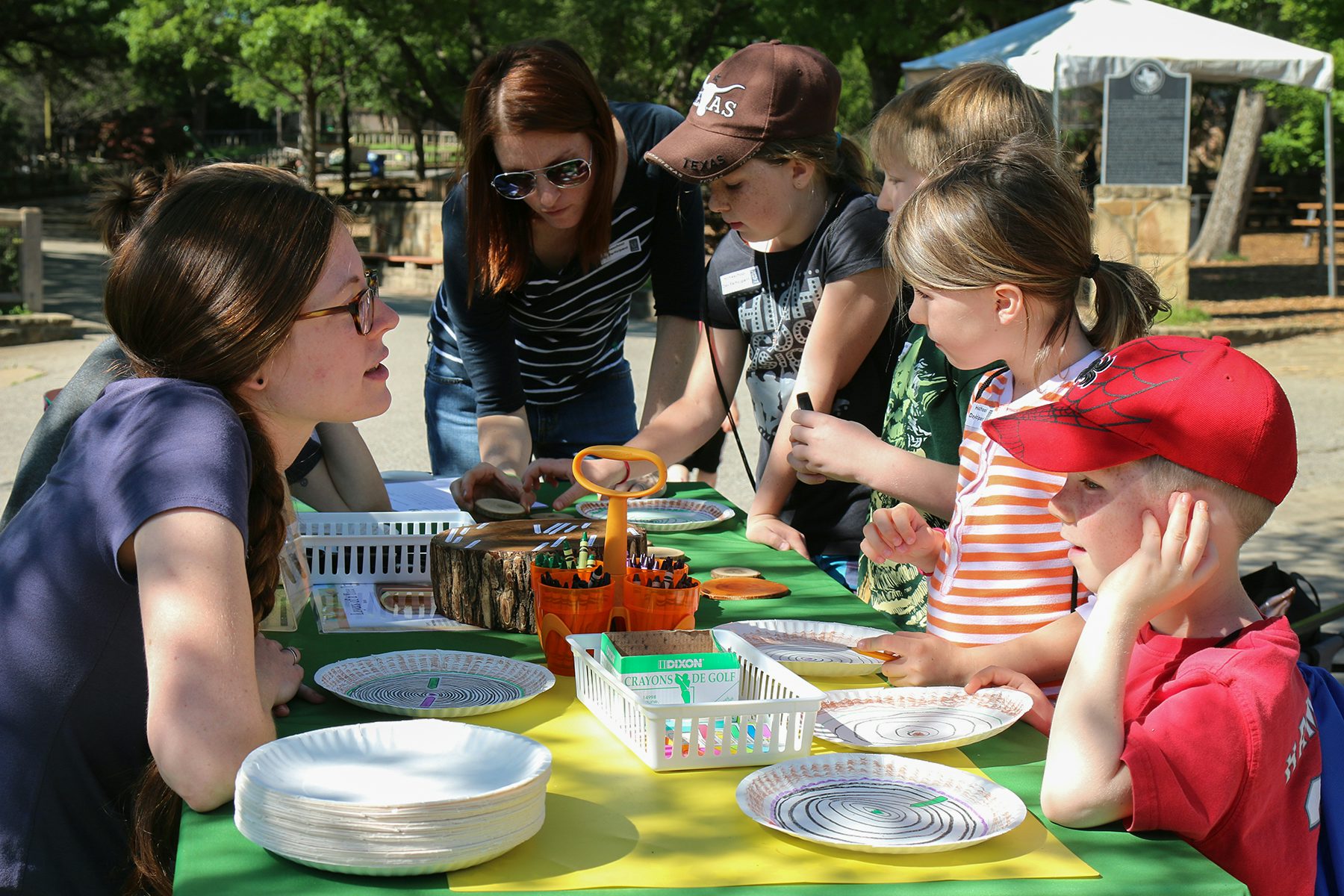 Parents and kids visiting educational booths during Homeschool Day at the Dallas Zoo